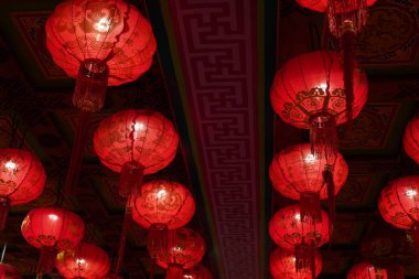 Many illuminated red Chinese lanterns with some Chinese characters on it