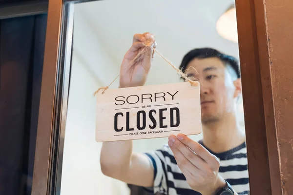 Asian male employee closing place with tablet — Stock Photo, Image
