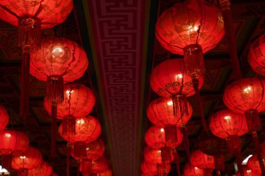 Many illuminated red Chinese lanterns with some Chinese characters on it