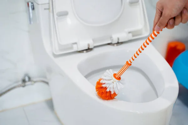 Guy lavaggio servizi igienici con spazzola — Foto Stock
