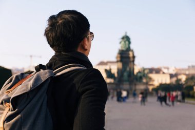 Avusturya, Viyana 'daki Maria Theresa Anıtı' nda sırt çantası taşıyan Asyalı erkek turist portresi