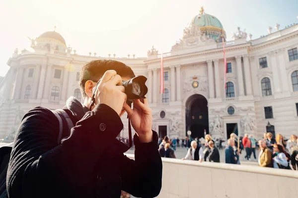 若いアジアの男性観光客が手にカメラで写真を撮るウィーン、オーストリア、ヨーロッパのホフブルク宮殿の近く。ヨーロッパで有名な人気の観光地 — ストック写真