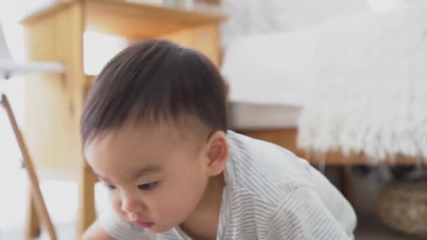 Baby-Junge kriecht auf dem Boden im Wohnzimmer drinnen. Kleinkind asiatische Familie zu Hause — Stockvideo