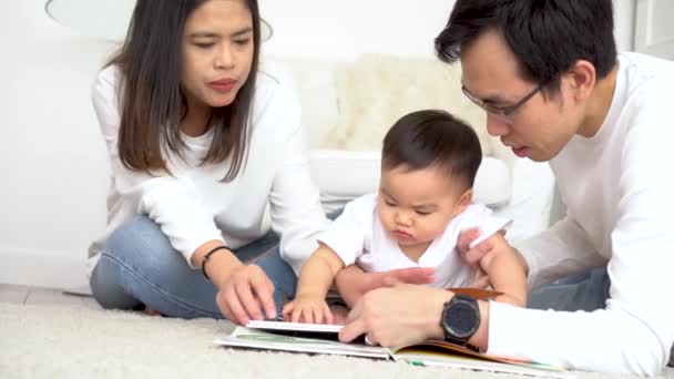 Jonge ouders lezen boek voor kleine zoon — Stockvideo