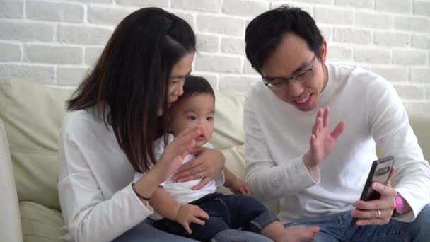 Szczęśliwa azjatycka rodzina wykonuje wideo połączenie w domu — Wideo stockowe