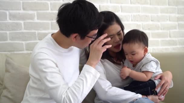 Asiática familia de padre y madre jugando con su hijo en sofá en casa — Vídeo de stock