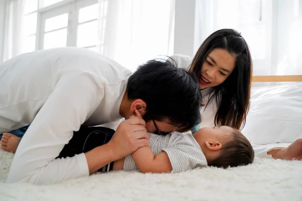 Rodina mladých asijských otec něžně líbání jeho dítě chlapec na břiše se svou ženou — Stock fotografie