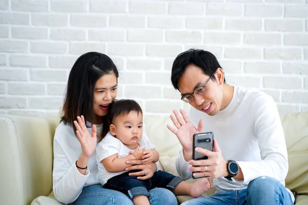 Feliz asiática familia hacer un video llamada en casa —  Fotos de Stock