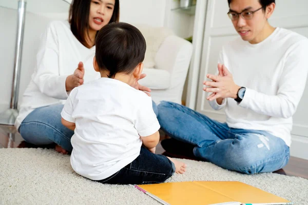 Feliz asiática familia de tres, joven padre y madre jugando juegos y aplaudiendo manos con bebé niño —  Fotos de Stock
