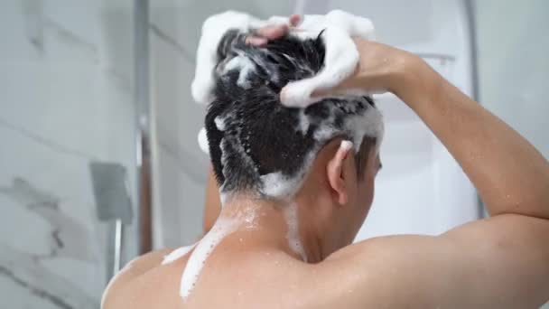 Mann benutzt Shampoo in der Dusche — Stockvideo