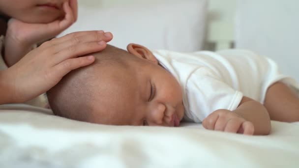 Küçük şirin kız kardeş Asyalı aile yeni doğan erkek kardeşe yatakta dokunuyor. — Stok video