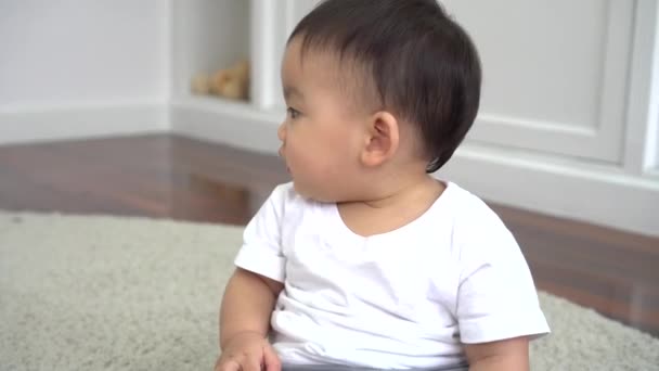 Asiático menino sentado no chão sozinho em casa ao lado da cama — Vídeo de Stock