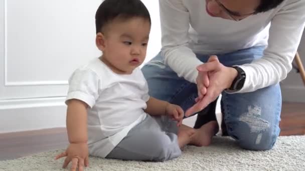 Szczęśliwa azjatycka rodzina młodego ojca bawi się w gry i klaska z małym chłopcem w domu — Wideo stockowe