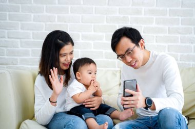 Happy Asian family making a video call at home