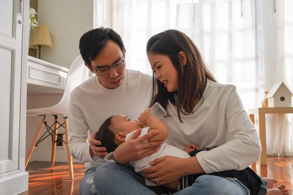 Azjatycka rodzina młodego ojca i matki karmiących chłopca z butelki mleka — Zdjęcie stockowe