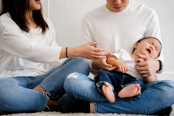 Азиатский голодный мальчик, жаждущий внимания родителей, пытающихся утешить его. Концепция "Родительство в Азии" — стоковое фото