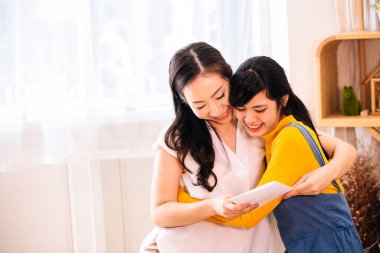 Kart ile Gülümseyen Asyalı anne ve kızı