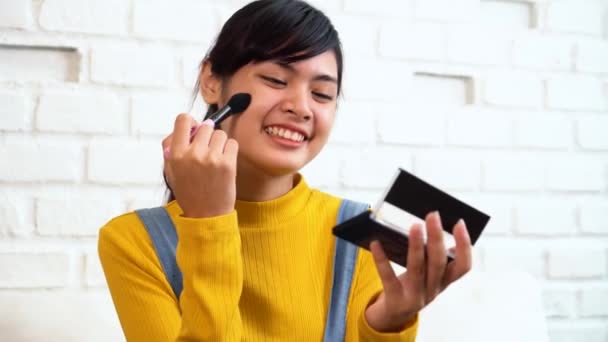 Tiener Aziatische meisje het aanbrengen van make-up terwijl zittend op de Bank — Stockvideo