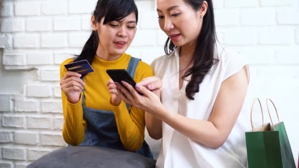 Alegres mujeres asiáticas de compras en línea usando teléfono inteligente — Vídeo de stock