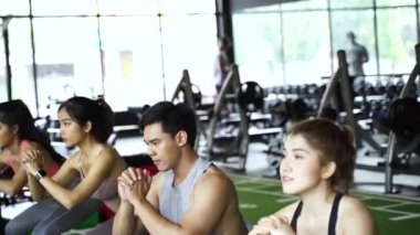Spor giyimli bir grup Asyalı genç sporcu spor salonunda spor yapıyor ve egzersiz yapıyor. Yoğun çalışma ve sağlıklı yaşam tarzı.