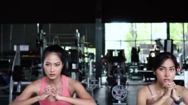 Spor kıyafetli bir grup genç Asyalı spor salonunda spor yapıyor ve egzersiz yapıyor.