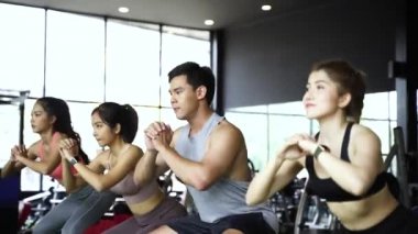 Spor giyimli bir grup Asyalı genç sporcu spor salonunda spor yapıyor ve egzersiz yapıyor. Yoğun çalışma ve sağlıklı yaşam tarzı