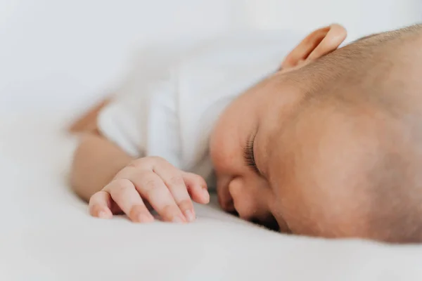 Novorozené dítě spí doma na břiše v posteli. Asijské dítě zdola nahoru spací pozice — Stock fotografie