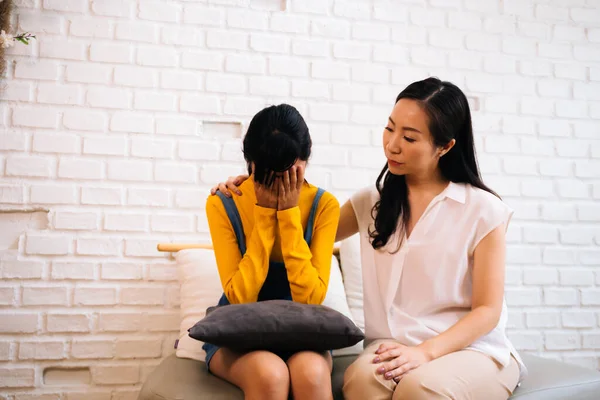 Asian mother comforting crying teenage daughter in miserable, stressed, depressed, sad state of mind — Stock Photo, Image