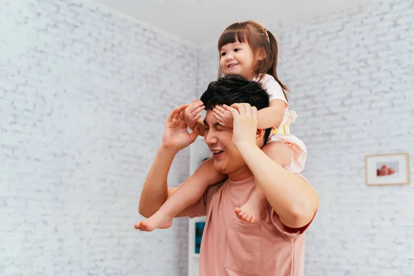 Asian father playing with daughter at home — стокове фото
