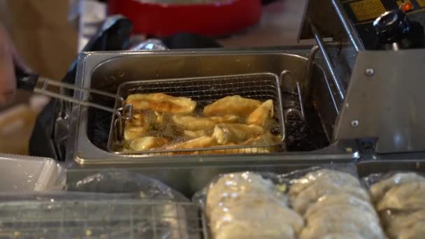 Gros plan du chef faisant une douzaine de gyoza japonais gras et gras - boulettes de porc et de chou japonais dans une casserole bouillante. Asias cuisine hors-d'œuvre . — Video