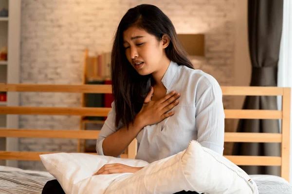 Retrato de una joven asiática de 20 años que tiene dificultad para respirar en el dormitorio por la noche. Dificultad para respirar, asma, dificultad para respirar — Foto de Stock