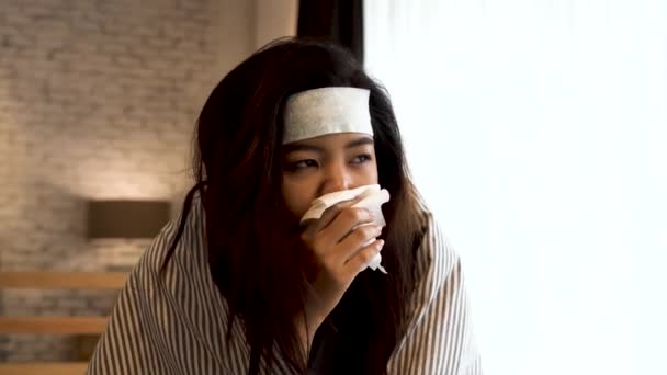 Giovane donna asiatica che soffre di freddo e malattia e sdraiata a letto con tessuto a casa — Video Stock