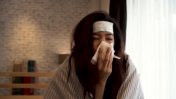 Young Asian woman suffering from cold and illness and lying in bed with tissue at home — Stock Video