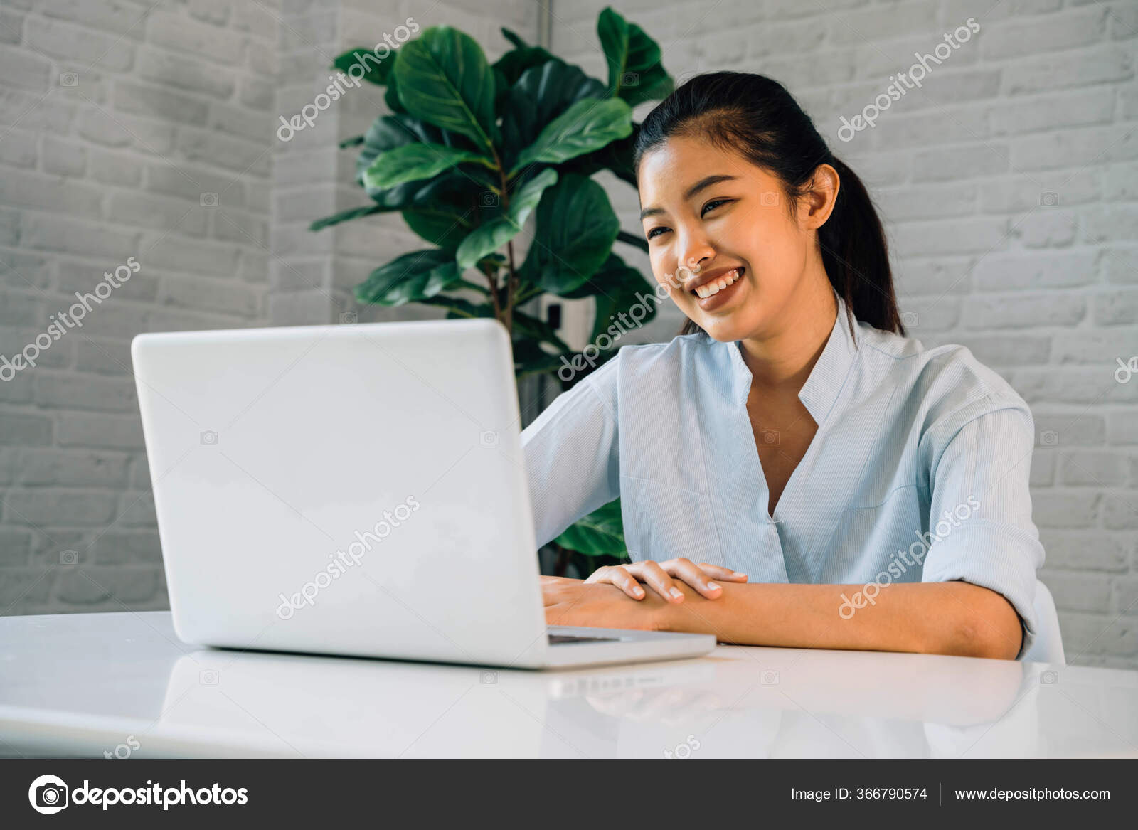 Happy friendly Asian woman using a laptop and talking, making video call  conference, online job interview