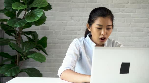 Mulher asiática amigável feliz usando um laptop e falando, fazendo videoconferência, entrevista de emprego on-line em casa. Millennial professor de internet feminino tutor e vlogger trabalhando em casa no trabalho — Vídeo de Stock