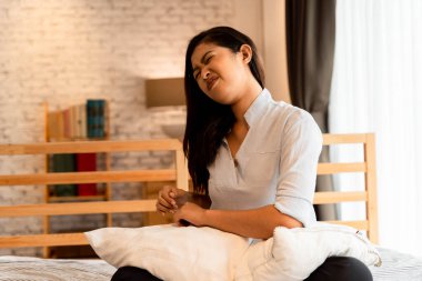 20 'li yaşlardaki Asyalı genç bir kadının portresi. Boynunda ve yatak odasında ağrı var. Vücut kası ağrıları