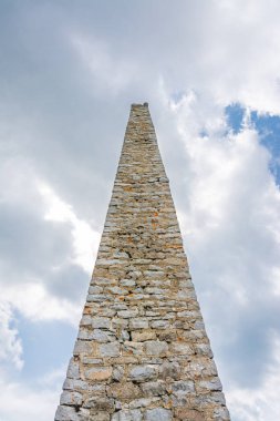 Beyaz bulutlar ve mavi gökyüzüne karşı yüksek taş dikilitaşın görüntüsü