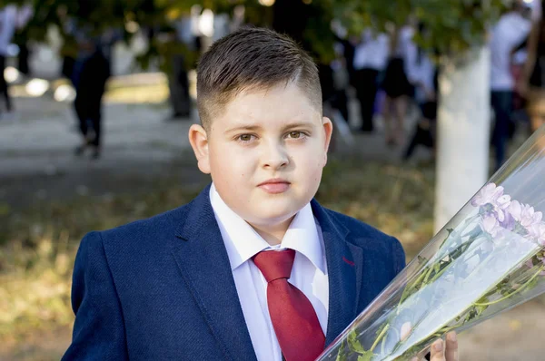 Uczeń szkoły w claret krawat z bukietem — Zdjęcie stockowe