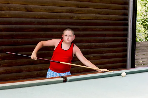 Çocuk açık havada bilardo oynuyor