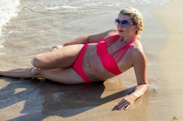 A mulher está em pernas de areia no mar — Fotografia de Stock
