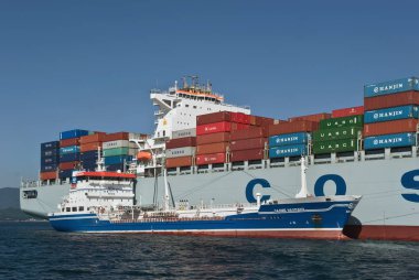 Nakhodka. Rusya - 06 Temmuz 2016: Bunkering tanker Zaliv'e Nakhodka bir büyük konteyner gemisi Cosco Pekin.