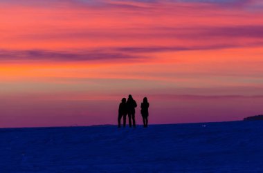 İnsanların günbatımı siluetleri turuncu kırmızı bulutlar akşam gece gökyüzü.
