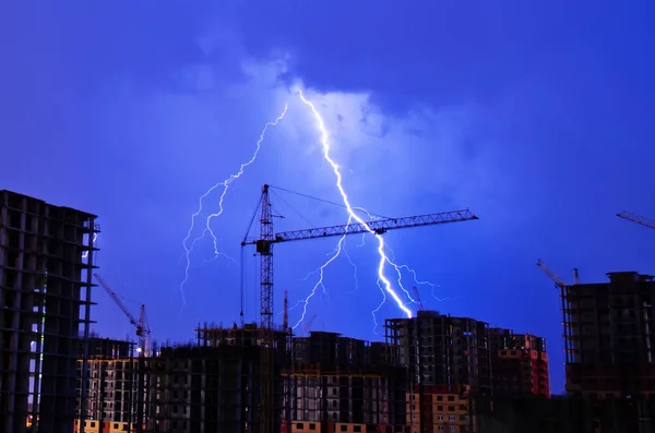 Lightning storm crane weather industrial city building construction night flash — Stock Photo, Image