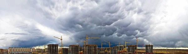 Construção guindaste concreto industrial arranha-céus tempestade chuva céu panorama — Fotografia de Stock