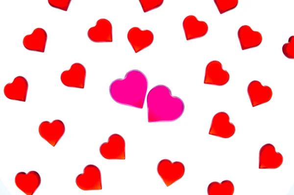 Corazones rojos brillantes sobre un fondo rayado con dos corazones rosados. Para utilizar el Día de San Valentín, bodas, Día Internacional de la Mujer — Foto de Stock