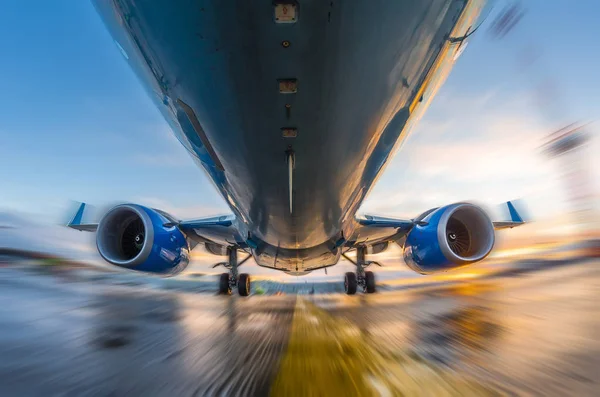 Airplane in motion during takeoff and landing, on a background of sunset and wet runway — Stock Photo, Image