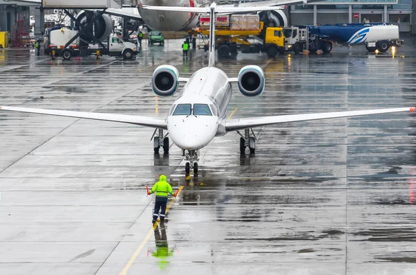Kołowania samolotu parking na lotnisku po lądowania człowieka wskazuje odległość do przystanku — Zdjęcie stockowe