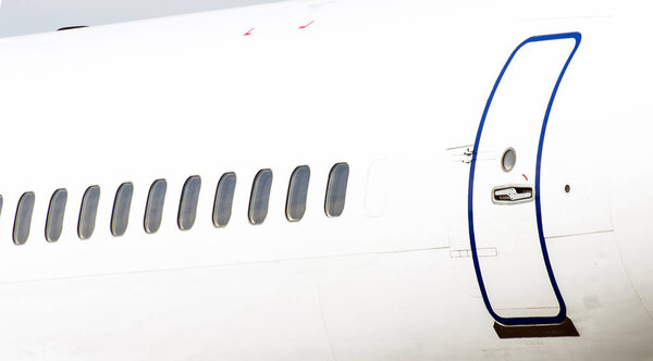 Many porthole on the big white plane and the door