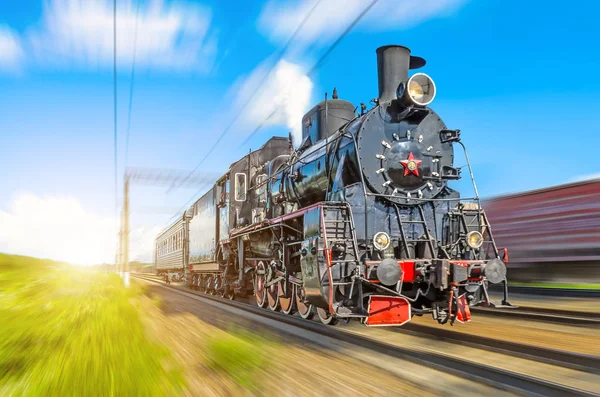 Retro old steam locomotive rushes at speed with a passenger train — Stock Photo, Image