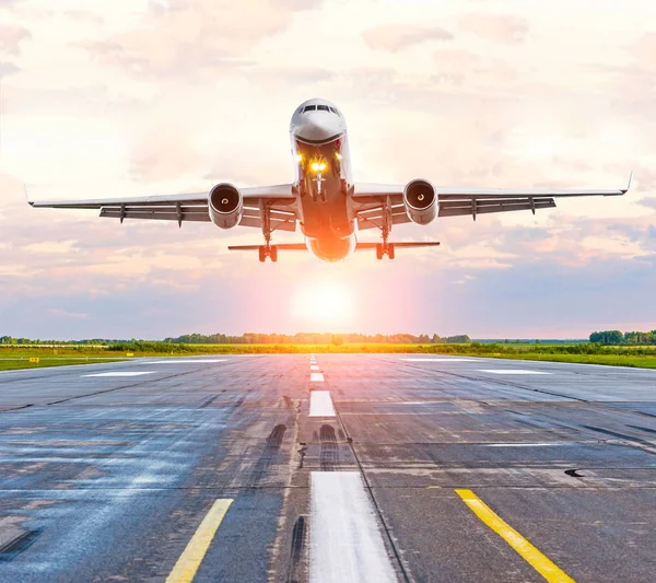 Avión aterrizando en la pista en el aeropuerto al atardecer — Foto de Stock